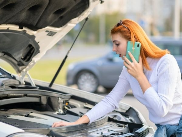 Woman Checking a Car's Engine